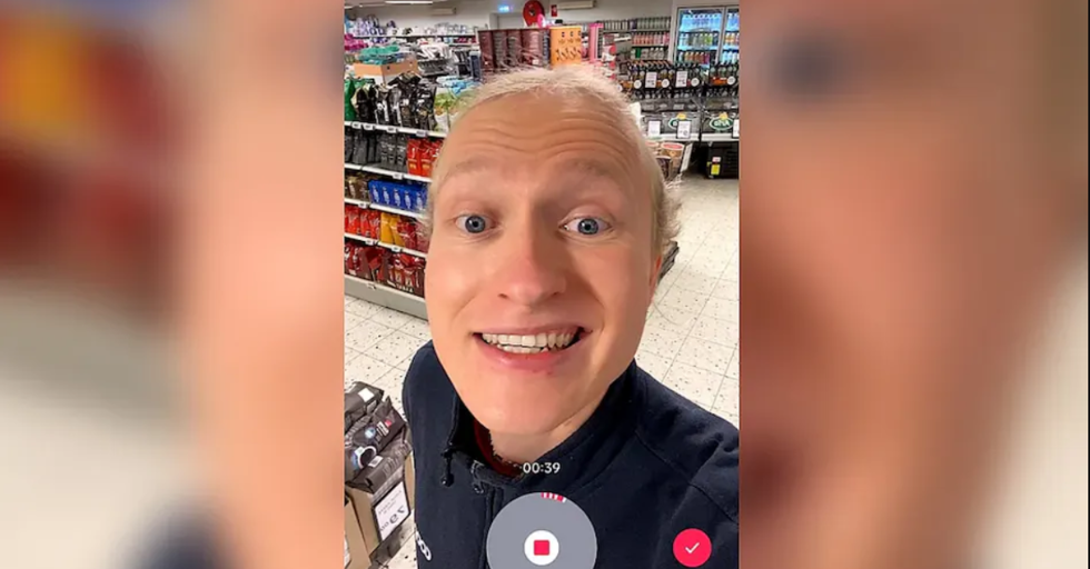 Person optager TikTok-video i en supermarkedsgang med hylder fulde af sodavand og slik