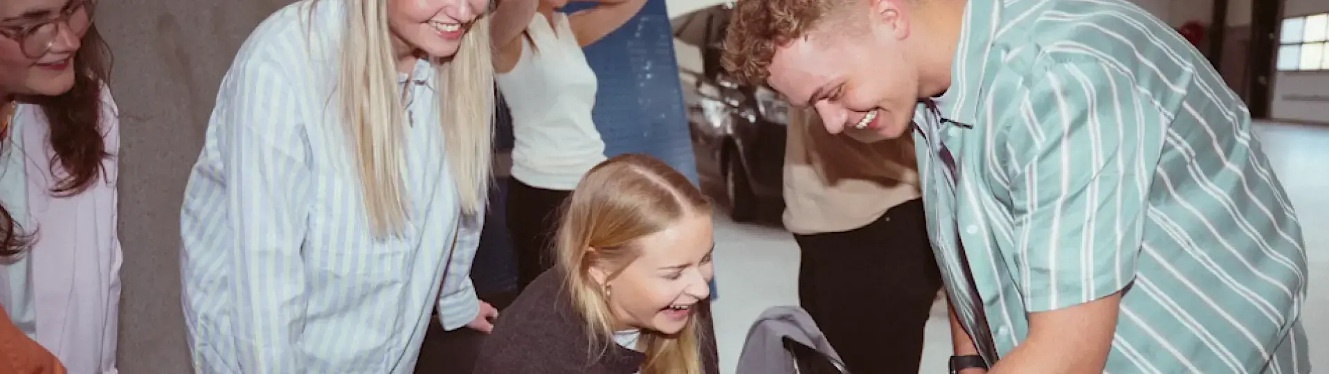 Elever samlet i en gruppe og kigger ned på noget foran dem