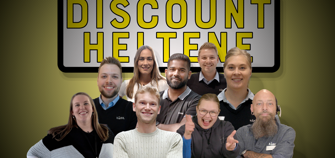 Gruppe medarbejdere samlet foran gult skilt med teksten Discount Heltene